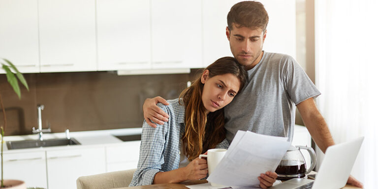 worried young couple reading bankruptcy paperwork for asset protection during Chapter 7, Chapter 13 bankruptcy