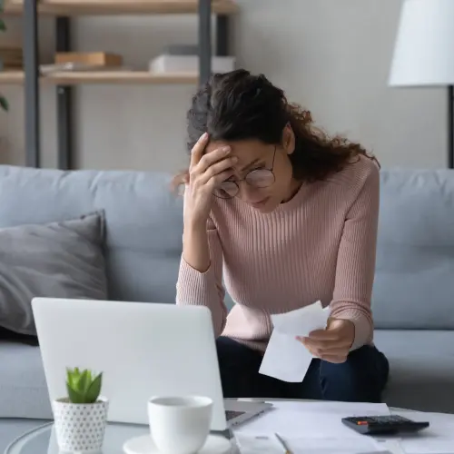 A young woman reviewing finances with the threat of bankruptcy looming.